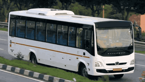 A 35 seater white bus on rent being driven on the highway