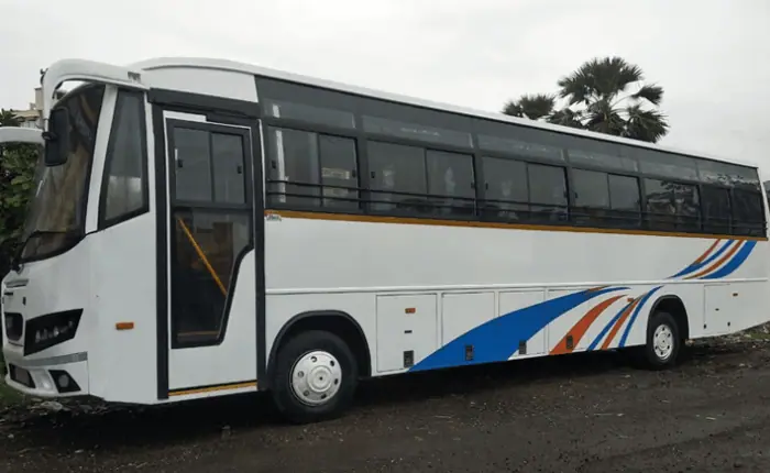 A white tempo traveller with shiny blue accents parked in a residential society in Andheri