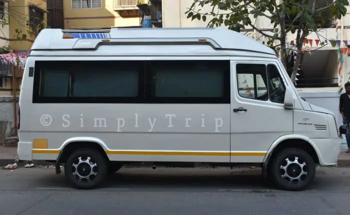 A 12 seater white tempo traveller parked near a neighbourhood in Dadar