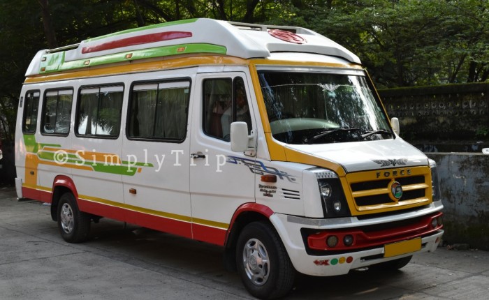 A 12 seater white tempo traveller parked near a neighbourhood in Dadar