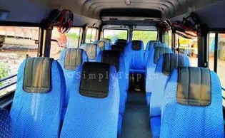A 12 seater white tempo traveller parked near a neighbourhood in Dadar