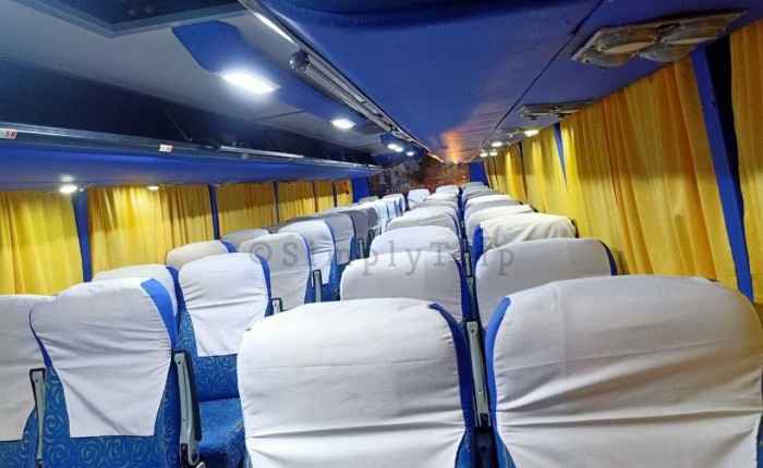 White coloured 40 seater bus with blue curtains
