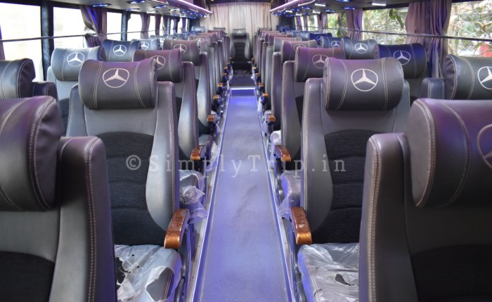 White coloured 40 seater bus with blue curtains